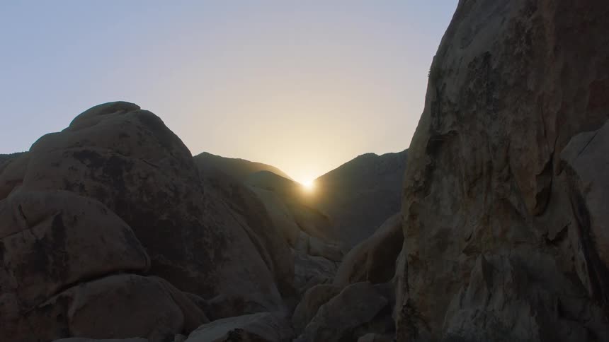 Sun rising through mountain peaks in the early morning