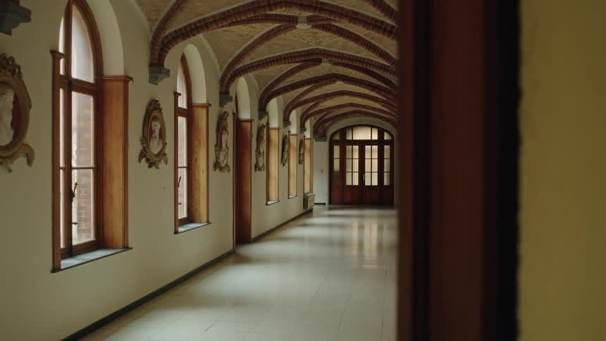A church hallway with tall ceilings and white tile floors