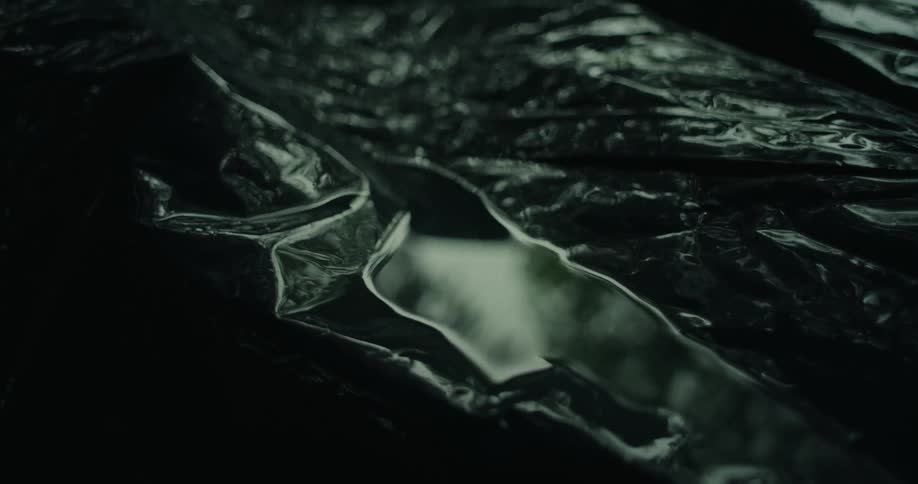 Close up of a reflection in a small puddle of water on a black tarp