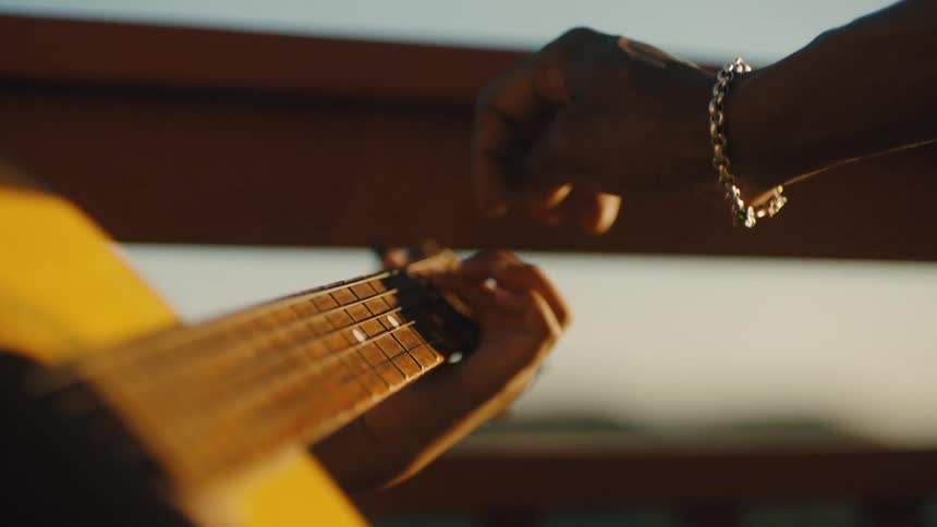 Hand teaching another person to play guitar