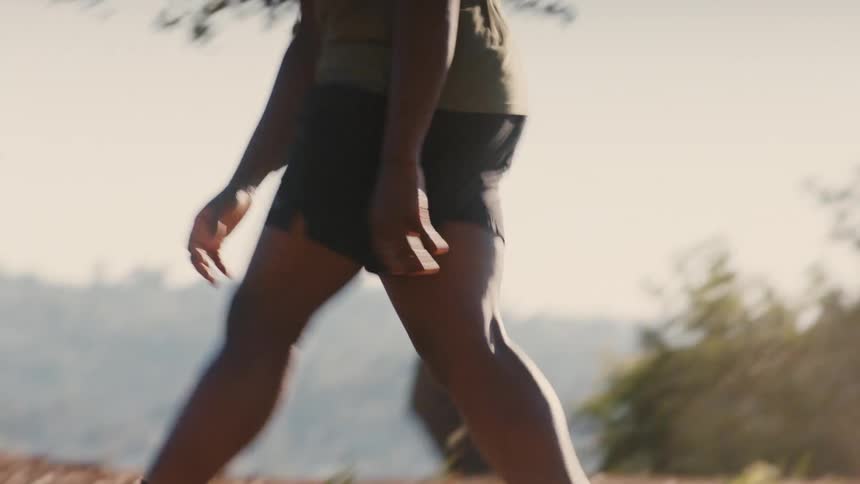 Two friends are playing soccer on a dirt surface kicking small clouds of dust
