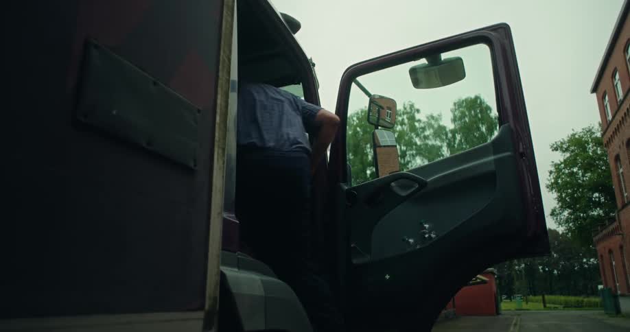 Elderly man getting into a truck and closing the door
