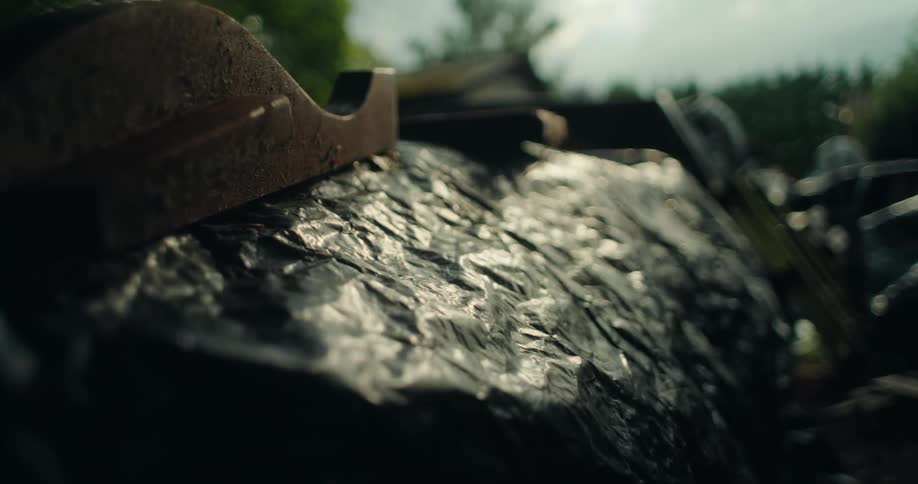 Close up of a black tarp covering items in a yard