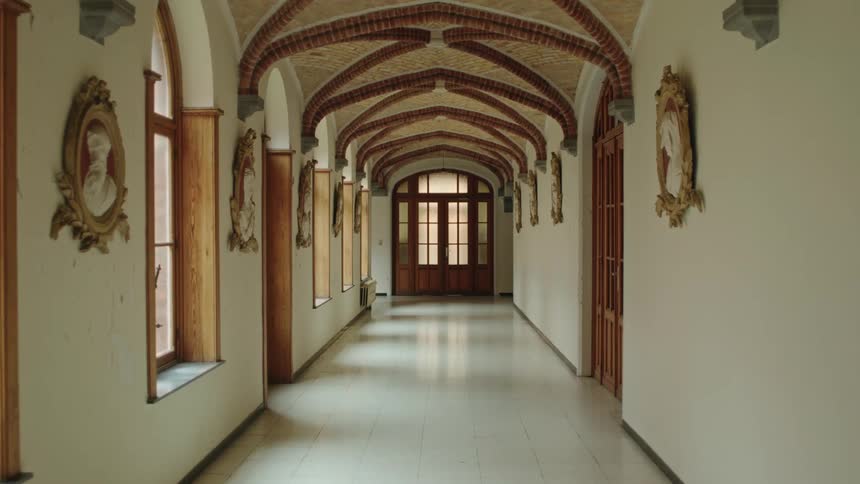 Interior of a hallway of a monsatery with art on the walls