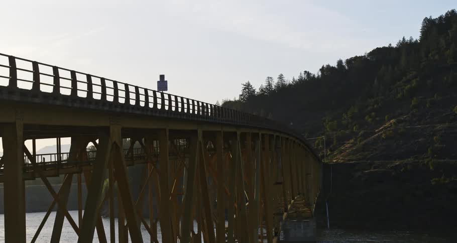 Aerial view of a bridge above the sea connecting to a mountain