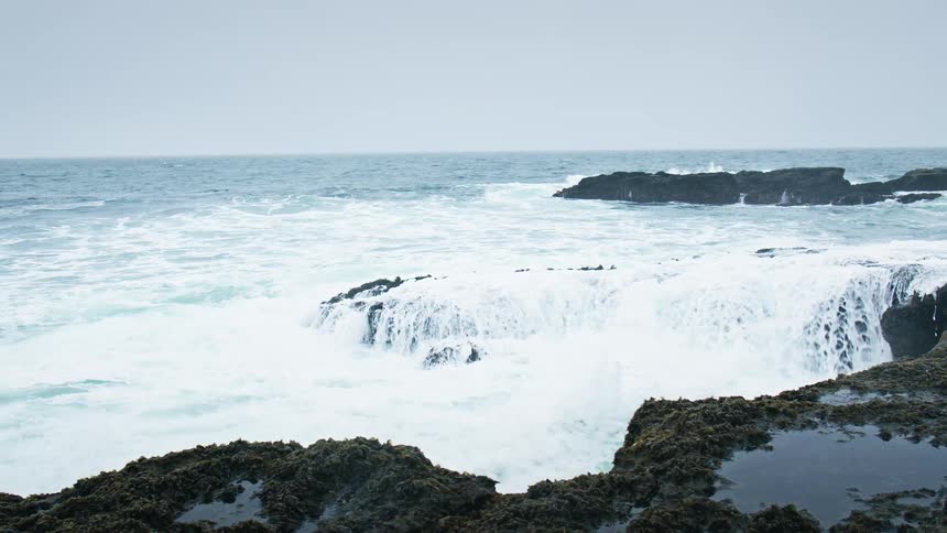 Some waves breaking on rocks on a sea shore