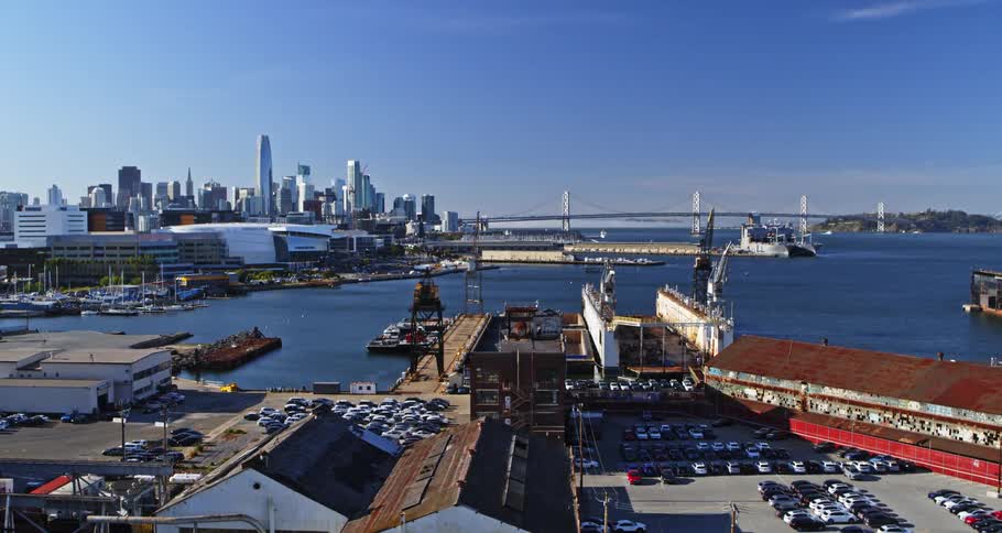 Aerial panorama of a port area with a metropolis and a bridge in the background
