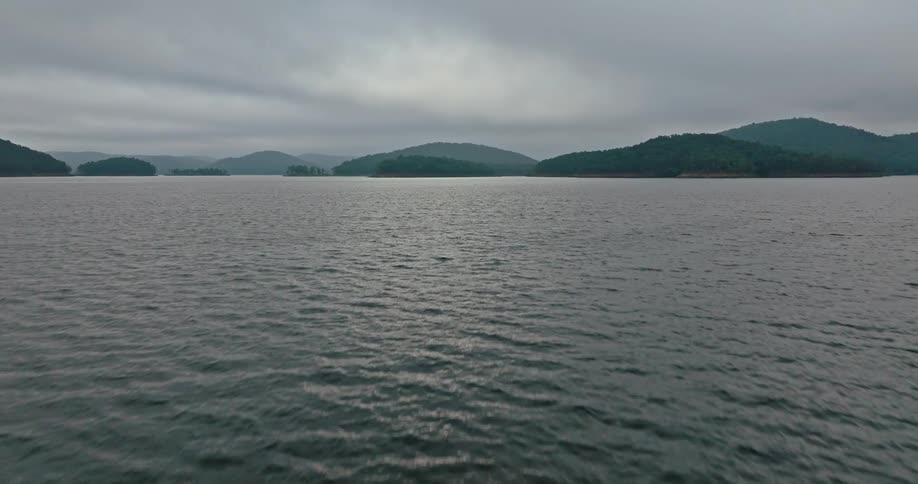 Aerial of choppy lake water with islands throughout the water on a cloud covered day
