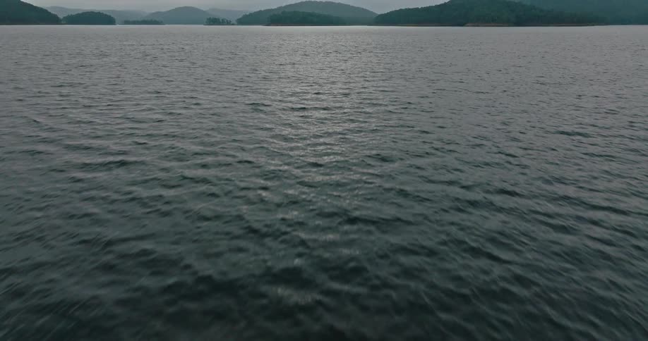 Aerial landscape of a vast ocean with mountains in the background on the horizon