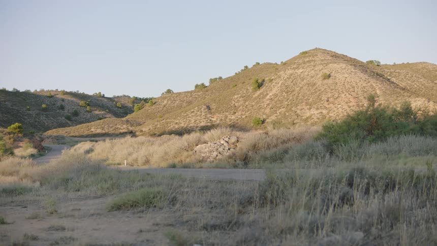 Hills in a natural environment with a highway in front and low vegetation