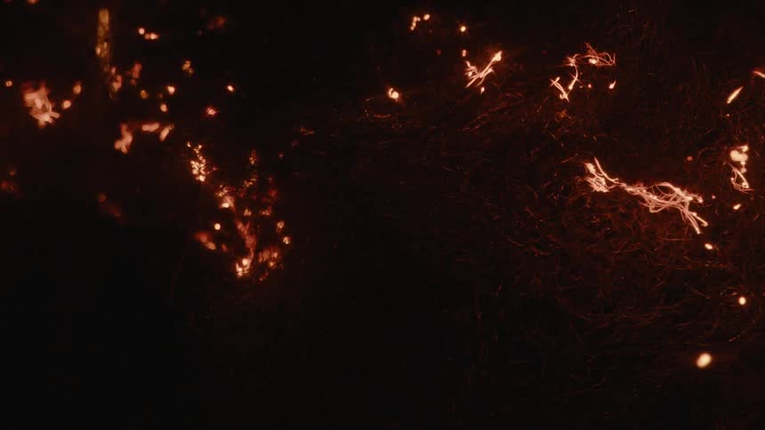 Sparks arc and burn outdoors at night