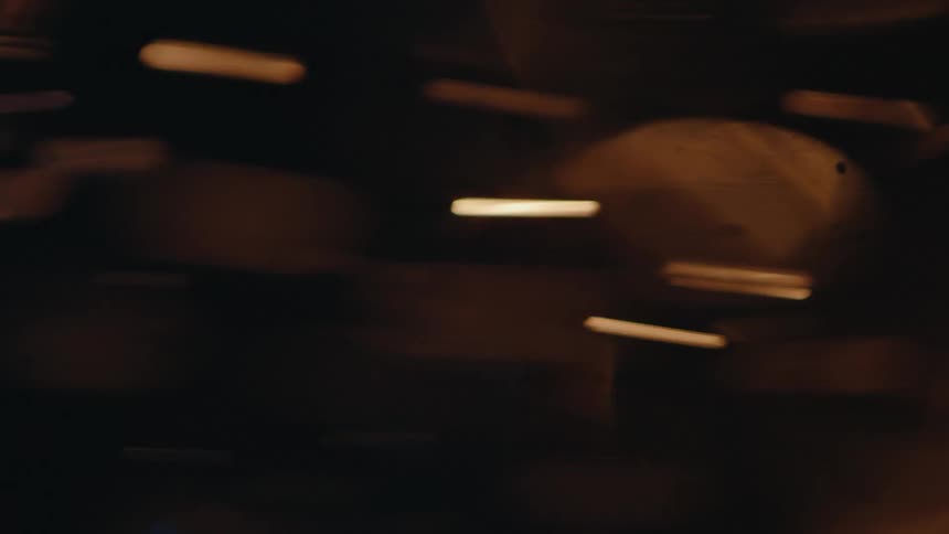 Translucent copper disks reflect the light while swirling through darkness