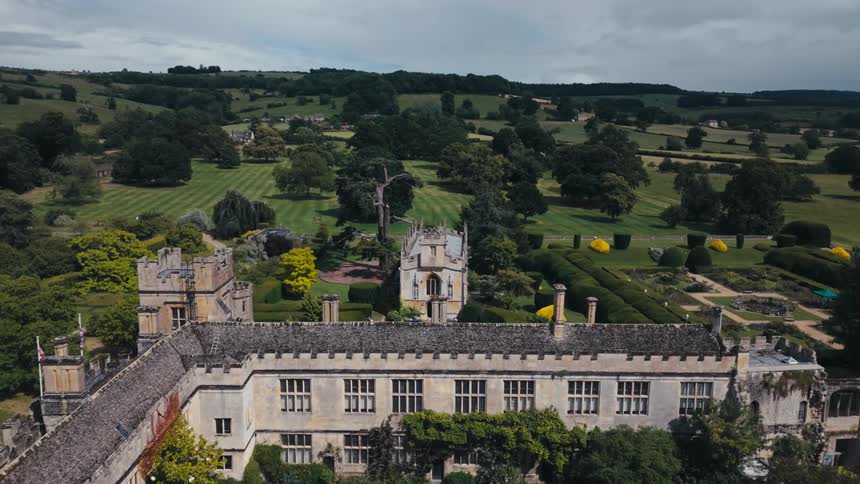 Elaborately landscaped estate with multiple large buildings stands in the rural countryside on a cloudy day