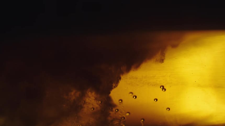 Extreme close up of a jet of liquid with bubbles and pressure