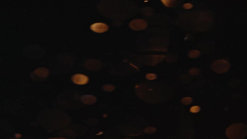 Translucent disks swirling through the dark reflect the light