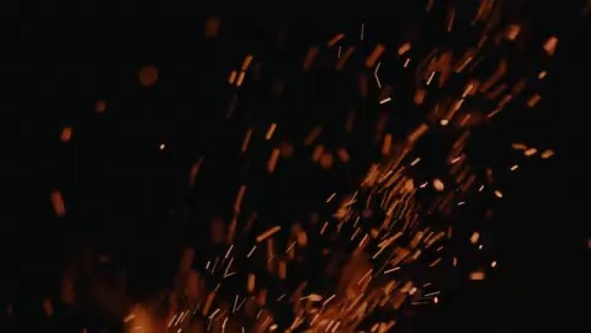 Sparks fly into a nighttime sky