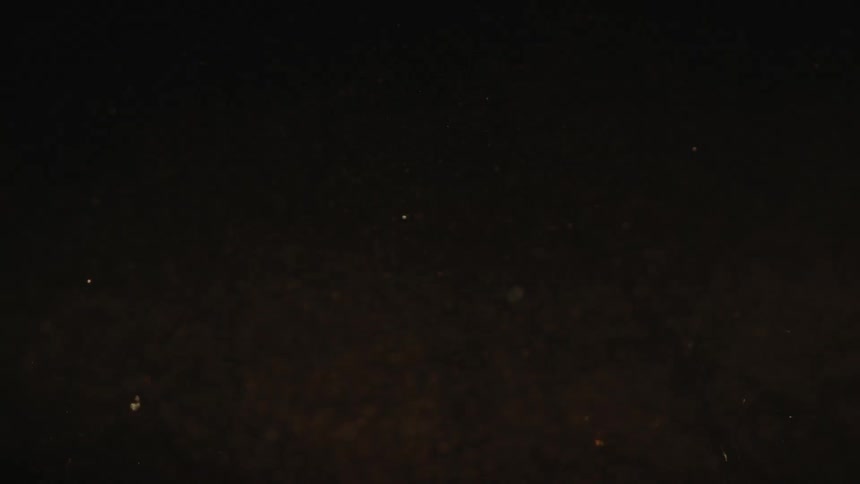 Closeup view of bubbles slowly rising in a dark liquid
