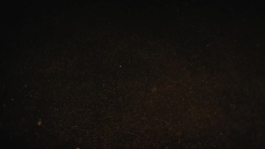Bubbles of various sizes float through a liquid in the darkness