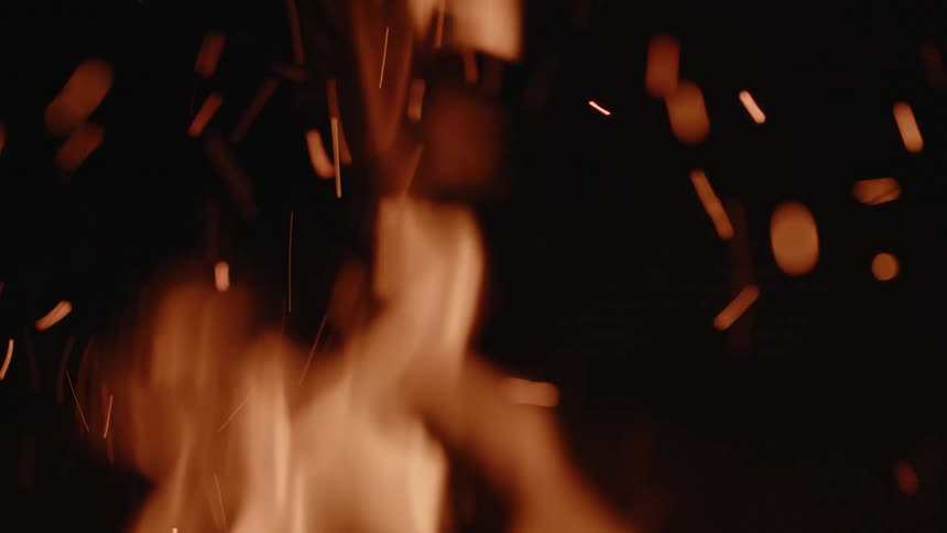 Bright orange sparks flying upwards against a dark background