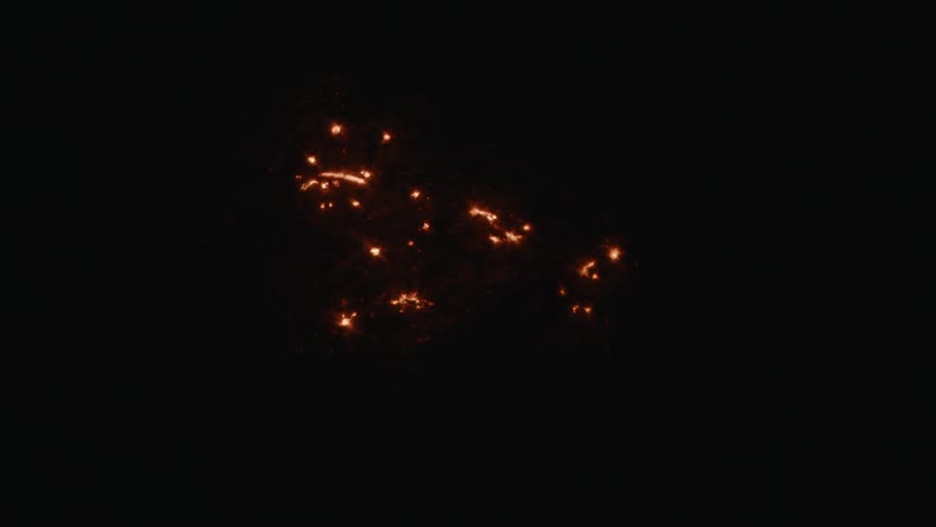 The sparks of a fire spread in the dark