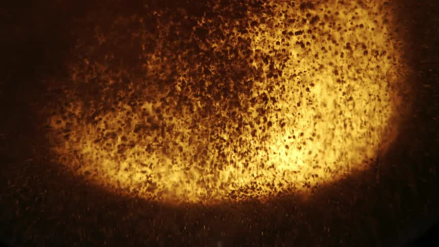 Closeup view of bubbles and foam in a goldenbrown liquid with light reflecting through it creating an amber glow