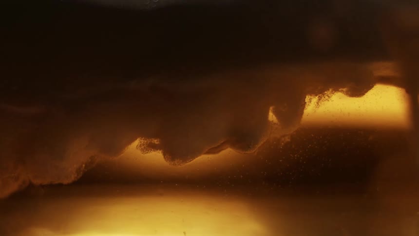 Foam moves in the yellow beer