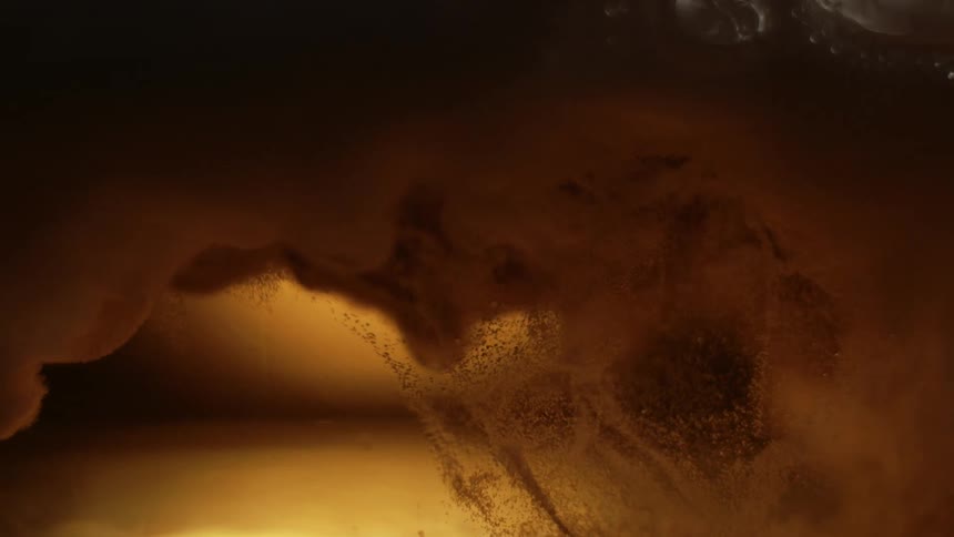 Amber beverage poured into a glass creates foam as it bubbles and fizzes