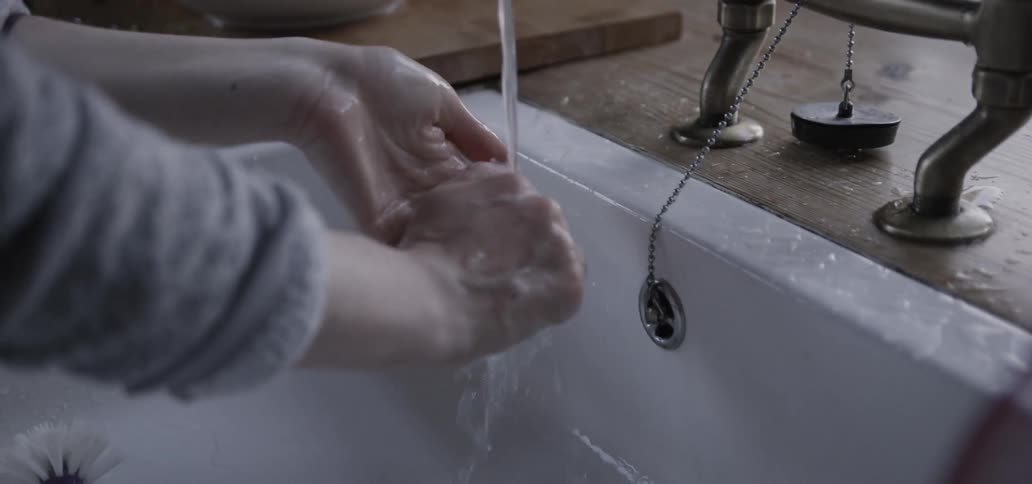 A woman washes her hands