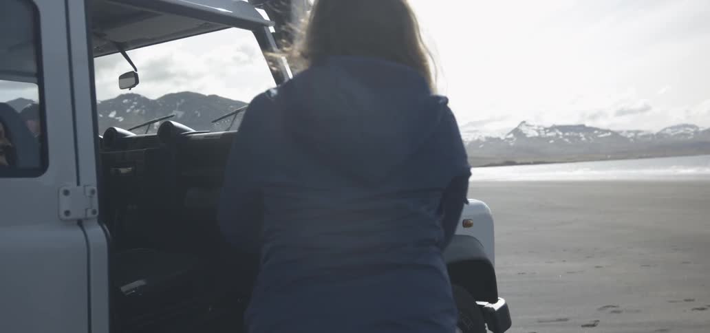 A woman exits from a white jeep