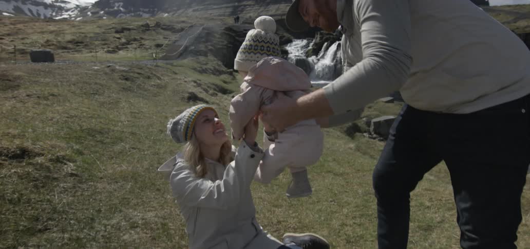 Man and woman playing with their infant in the wilderness