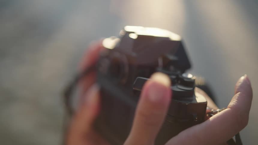A womans hand preparing the roll on a vintage analog film photo camera