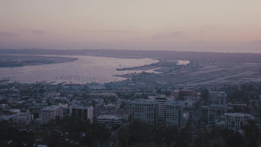 The sun is rising on the city by the river