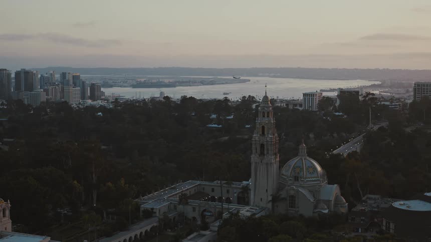 A plane approaches San Diego International Airport to land at dusk