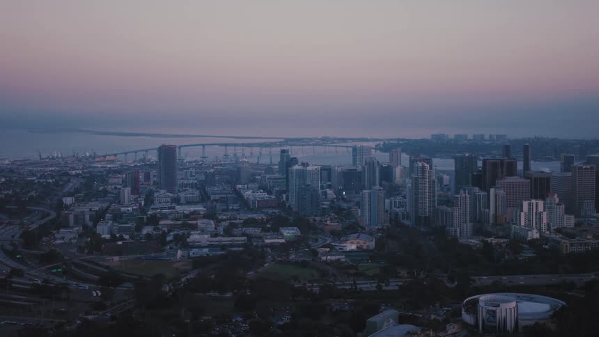 An aerial view of a metropolitan center with several buildings and it is getting dark