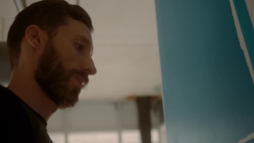 A man is painting on a canvas