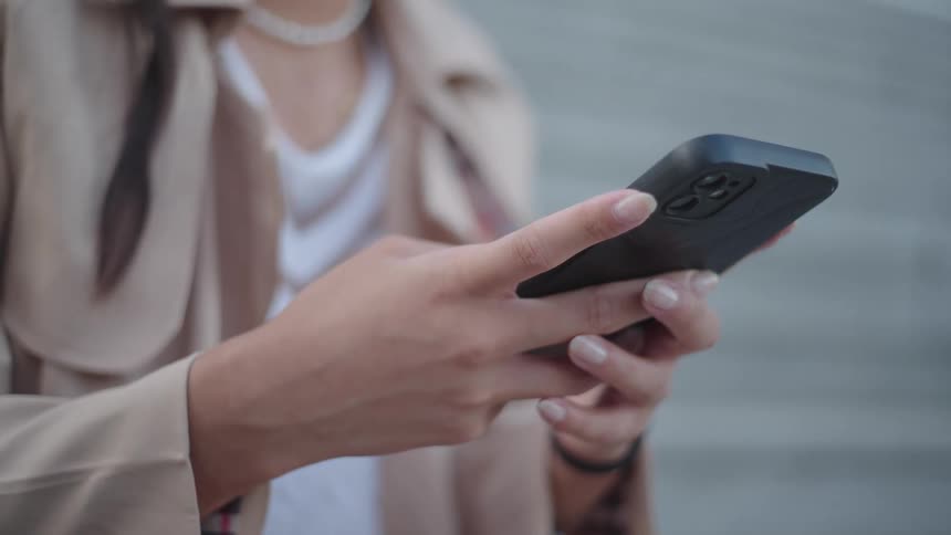 A closeup of an individuals hands holding and operating a smartphone