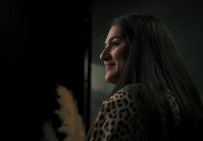 A woman smiles while sitting near photography lighting