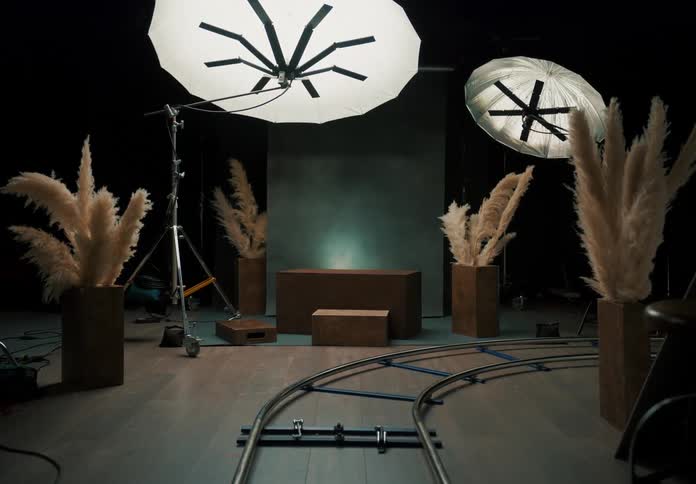 A studio for photography with lights set up plants and a track around the studio