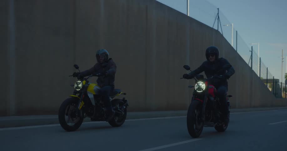 Three bikers on a city freeway talking to each other while riding