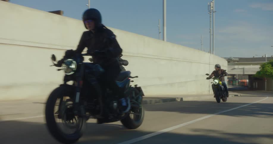 Three motorcyclists ride down a city street
