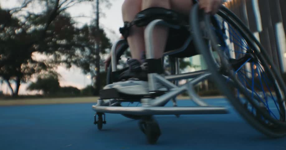 A person spins in their wheelchair as they dribble a basketball