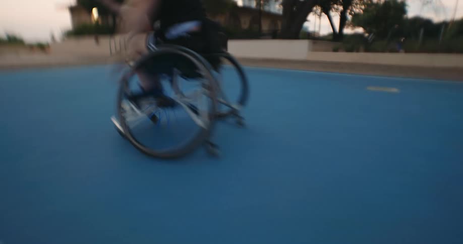A woman in a wheelchair in motion on a basketball court