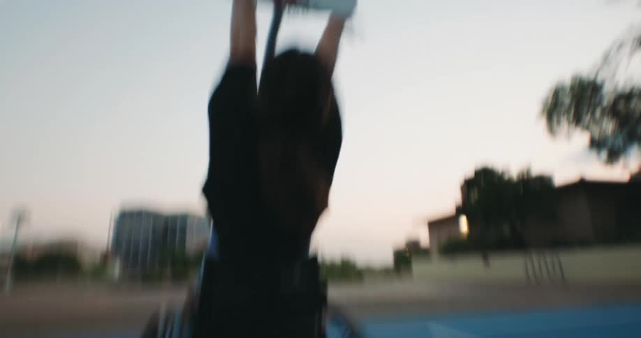 A woman in a wheelchair shoots the basketball