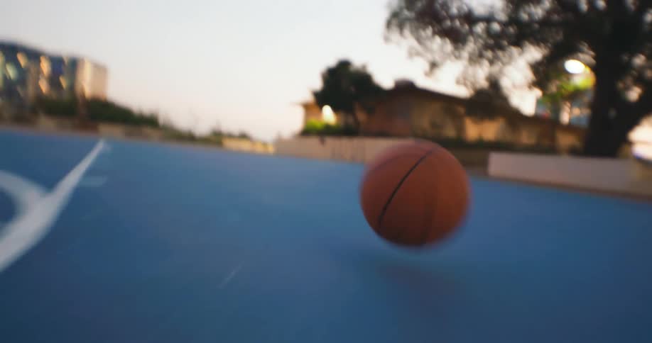 Time lapse of a basketball bouncing on the floor of an outdoor basketball court
