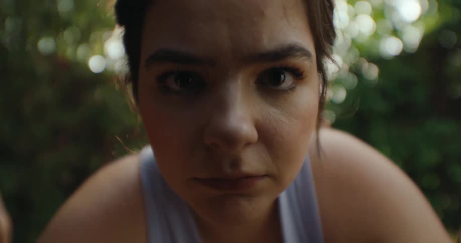The face of a young woman looking forward and she moves closer