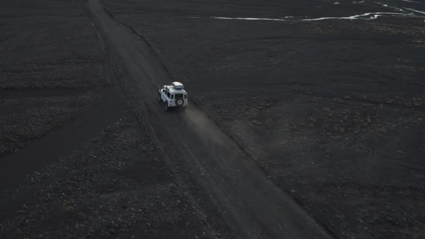 A land rover drives down a dirt road