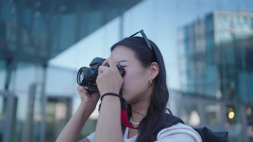 A young woman with long black hair is taking a picture with a camera