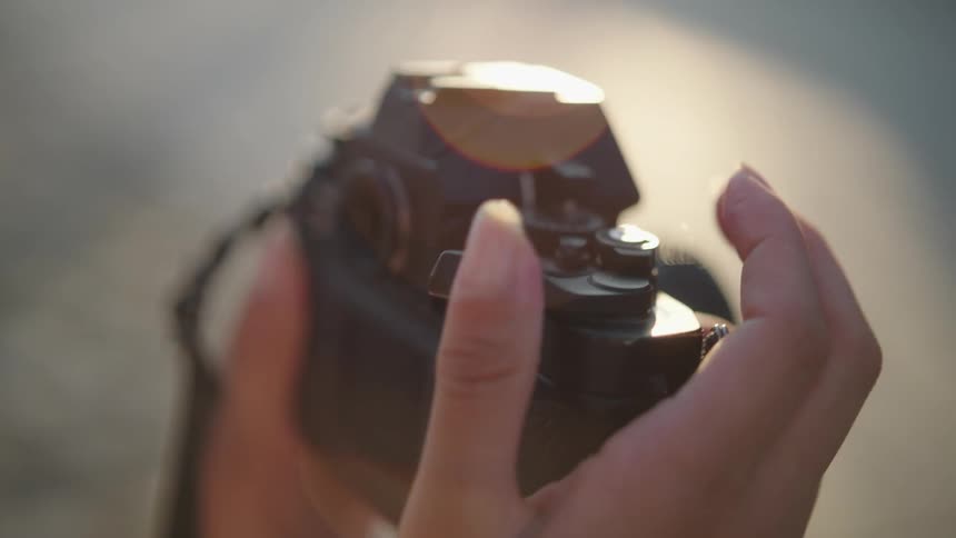 A person is turning the switch on a vintage analog film camera