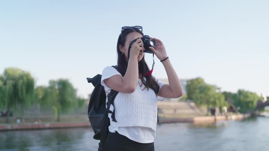 A woman photographer holding a camera up to her face to take a picture before taking it down again