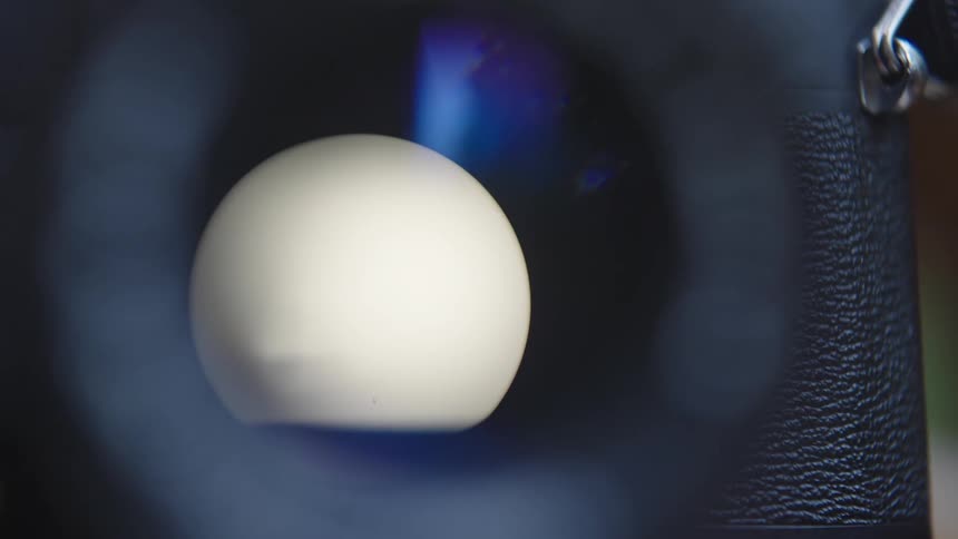 A camera shutter is seen through the lens as someone takes a photo
